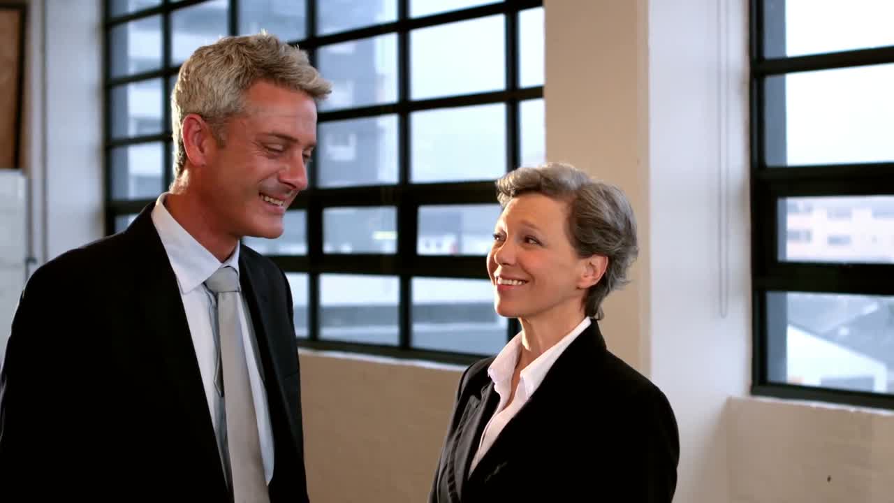 Zakenkoppel dat praat en lacht naar de camera