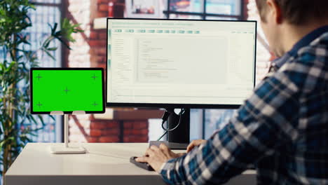man in home office fixing errors in application using chroma key device and pc