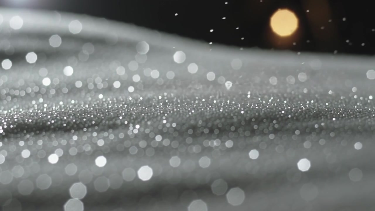 Rivelazione di una superficie scintillante e strutturata che riflette un caldo bokeh notturno, con l'inizio di una leggera nevicata