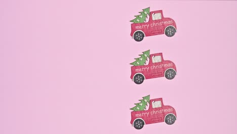 three merry christmas wooden cars with christmas tree passing on pastel pink theme. stop motion