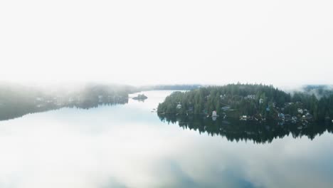 Foggy-aerial-shot-of-the-Indian-Arm-fjord-in-North-Vancouver-on-an-early-morning-sunrise-with-powerful-reflections-,-Deep-Cove