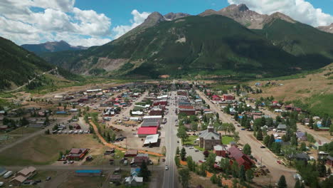 Aerial-cinematic-drone-summer-morning-downtown-Silverton-Main-Street-southern-Colorado-stunning-lush-green-blue-sky-partly-cloudy-Rocky-Mountains-town-forward-reveal-movement