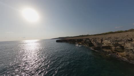 Low-FPV-aerial-flight-along-vertical-rock-sea