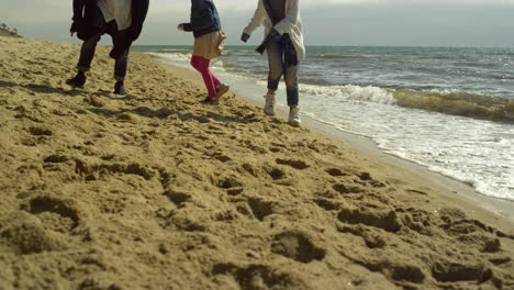 Las-Piernas-Familiares-Juegan-Juntas-En-La-Playa-A-La-Orilla-Del-Mar.-Gente-Divertida-Caminando-Junto-A-Las-Olas-Del-Océano.