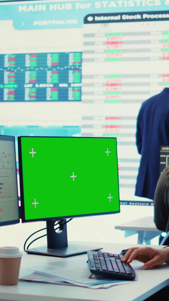 Mani che digitano sulla tastiera con monitor con schermo verde in ufficio moderno