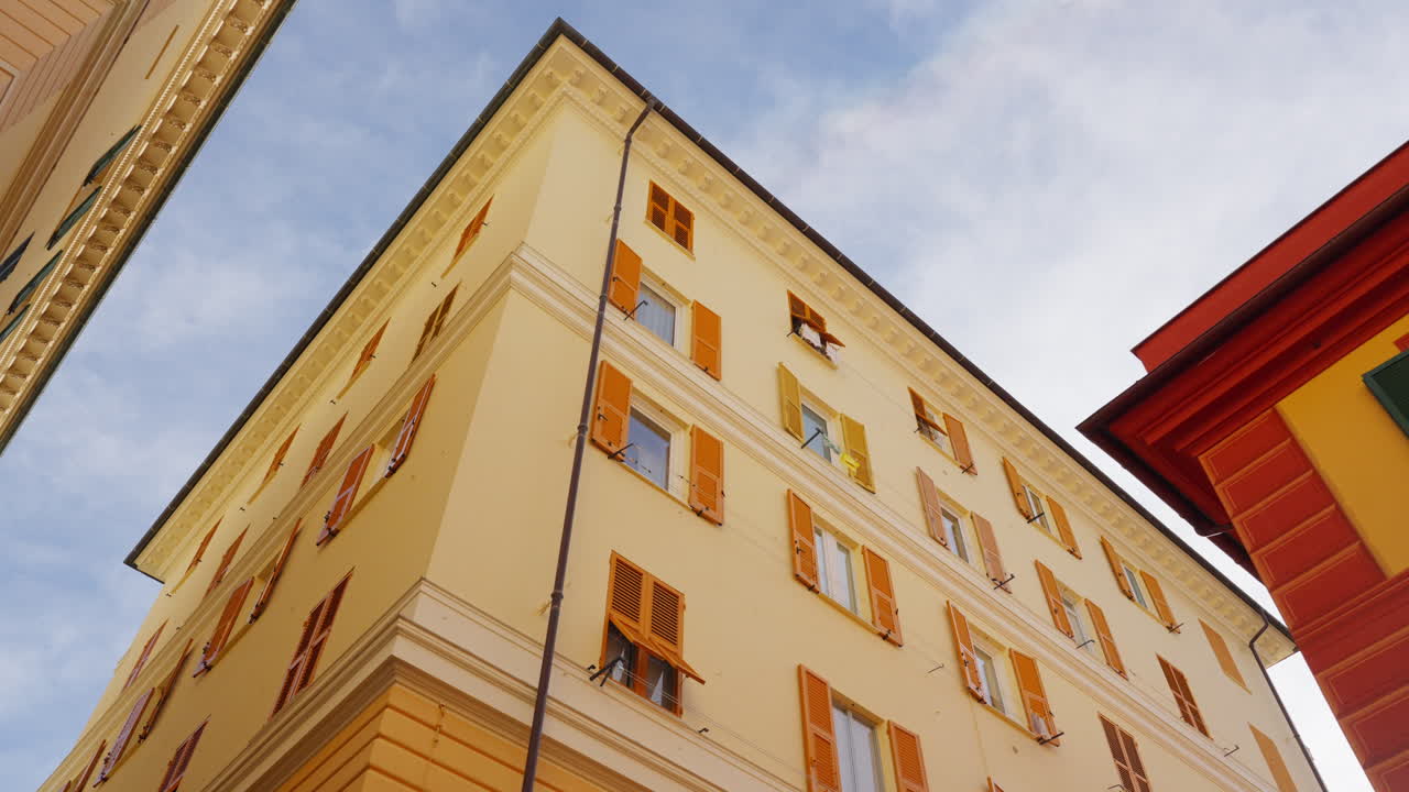 Vista de ângulo baixo de edifícios coloridos na cidade velha de Gênova com a câmera movendo-se ligeiramente entre as fachadas