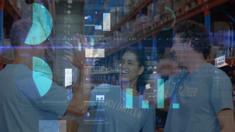 Screens-with-data-processing-against-male-and-female-volunteers-high-fiving-each-other-at-warehouse