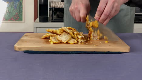 A-Japanese-female-chef-removes-kernels-from-the-corncob-at-home-kitchen,-Tokyo,-Japan