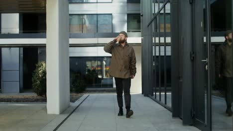 man drinking coffee outdoors in city