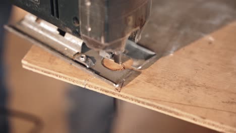 cutting plywood board with electric tool, close up view