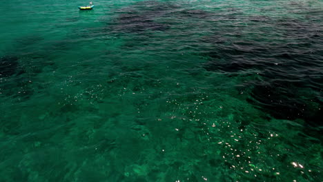 Blue-Green-Sea-With-Moored-Boats-During-Summer-In-Sardinia,-Italy---aerial-drone-shot