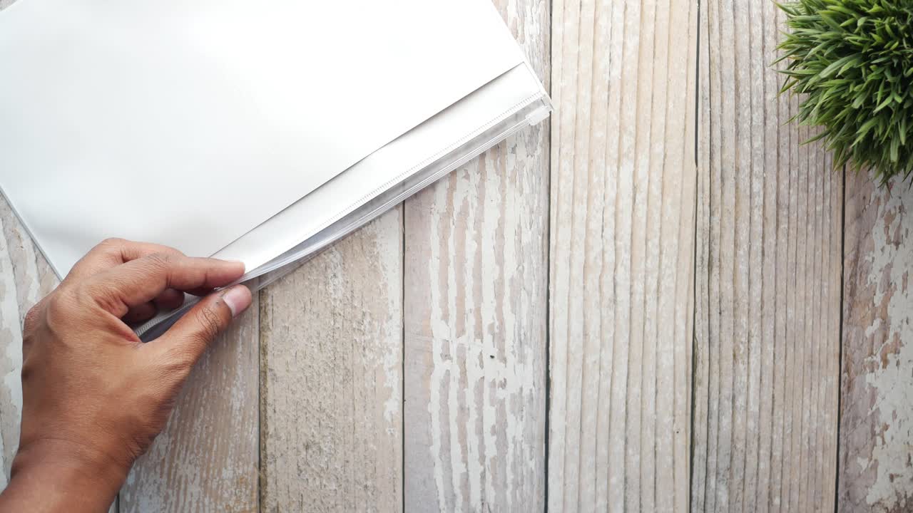 젊은 남자가 주머니에 사무실 서류를 넣고 있는 탑 뷰