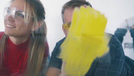 man-and-woman-paint-wall-with-different-colors-smile-kissing