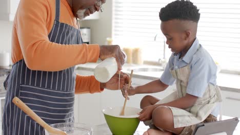 Glücklicher-Afroamerikanischer-Großvater-Und-Enkel-Beim-Backen-In-Der-Küche,-Zeitlupe