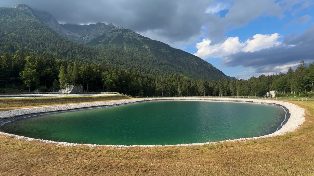 Bacino artificiale nelle Alpi Giulie, Friuli, immagazzina acqua per l'innevamento artificiale poiché le nevicate naturali diminuiscono a causa del cambiamento climatico