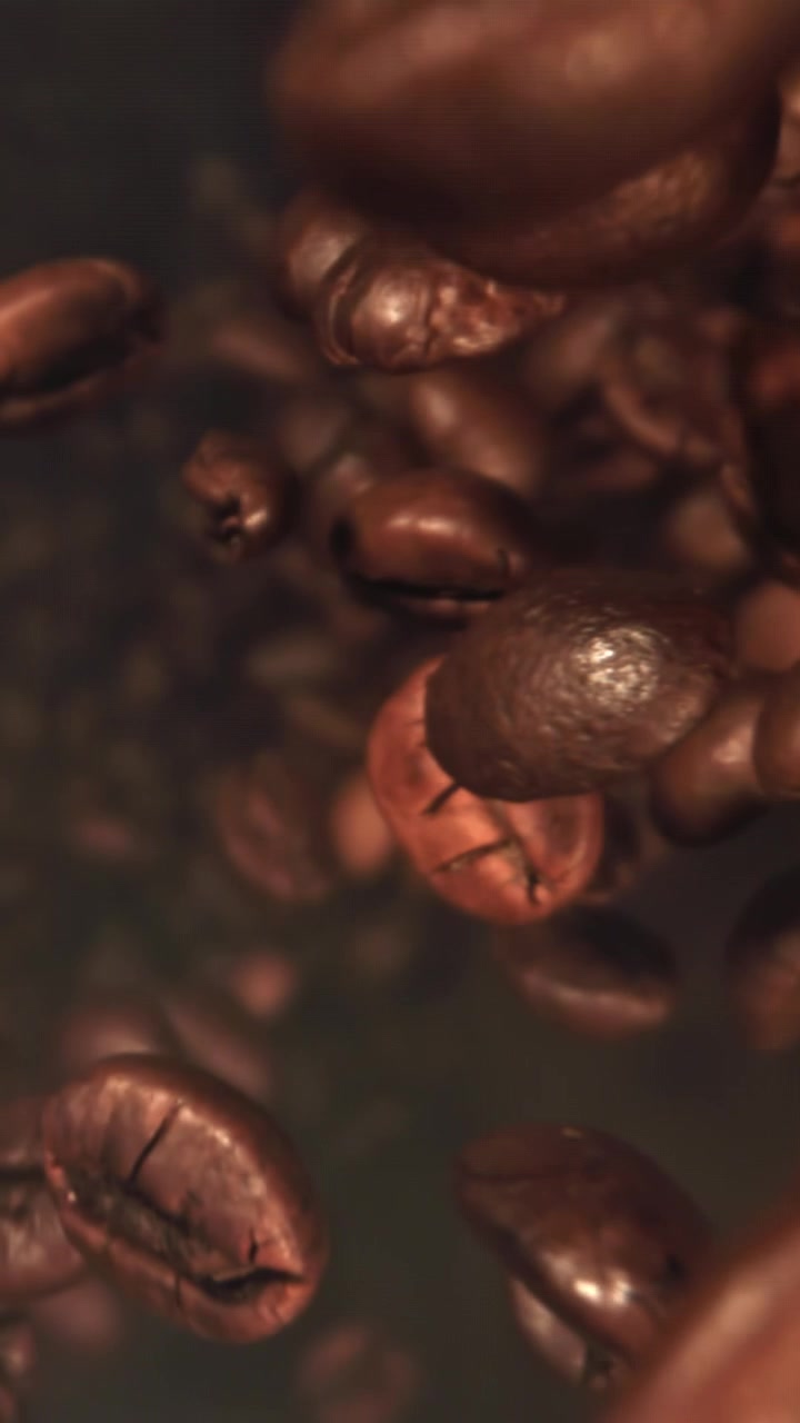 Chicchi di caffè tostati che cadono al rallentatore su sfondo scuro
