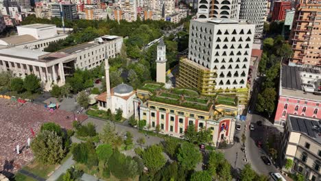orbiting aerial view of the historic et'hem bey mosque in the capital city of tirana, albania, showcasing its unique architecture and prominent location within the urban landscape near skanderbeg.