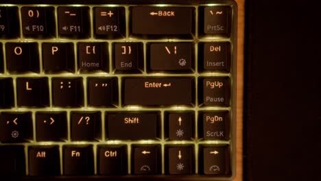 manos escribiendo en un teclado negro en un escritorio de madera personalizado