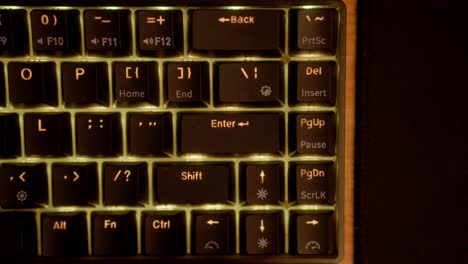 hands typing on a black keyboard on wooden custom desk