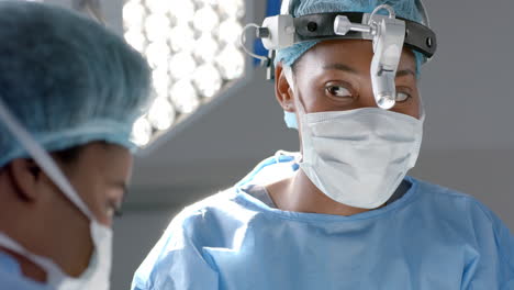 african american female surgeons operating on patient in operating theatre, slow motion