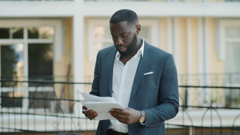 afro businessman examining documents outdoor