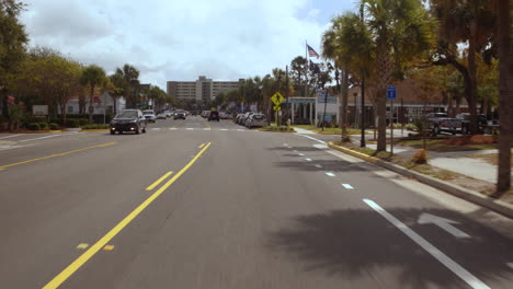 driving plate front, car driving through folly beach strip, day