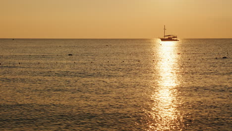 fishing boat in the sea at sunrise a beautiful silhouette in a shiny path on the water 4k video