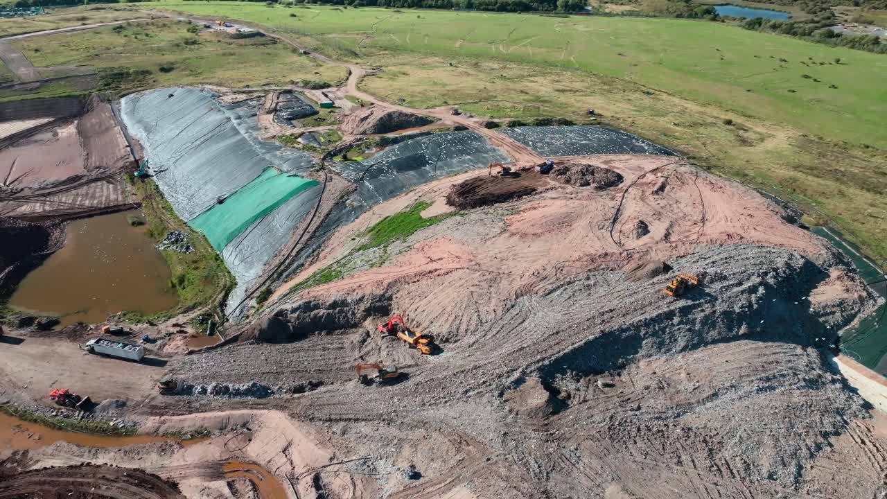 Bulldozer Pushing Garbage Up And Scavenging Seagulls Flying At Landfill Site. Jameson Road Landfill And Recycling Site, Fleetwood, UK