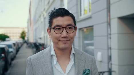 smiling korean businessman walking in city