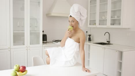 woman after shower eating apple