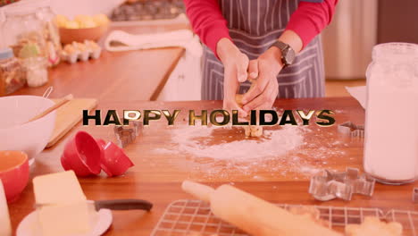 animation of happy holidays text over caucasian man baking in kitchen