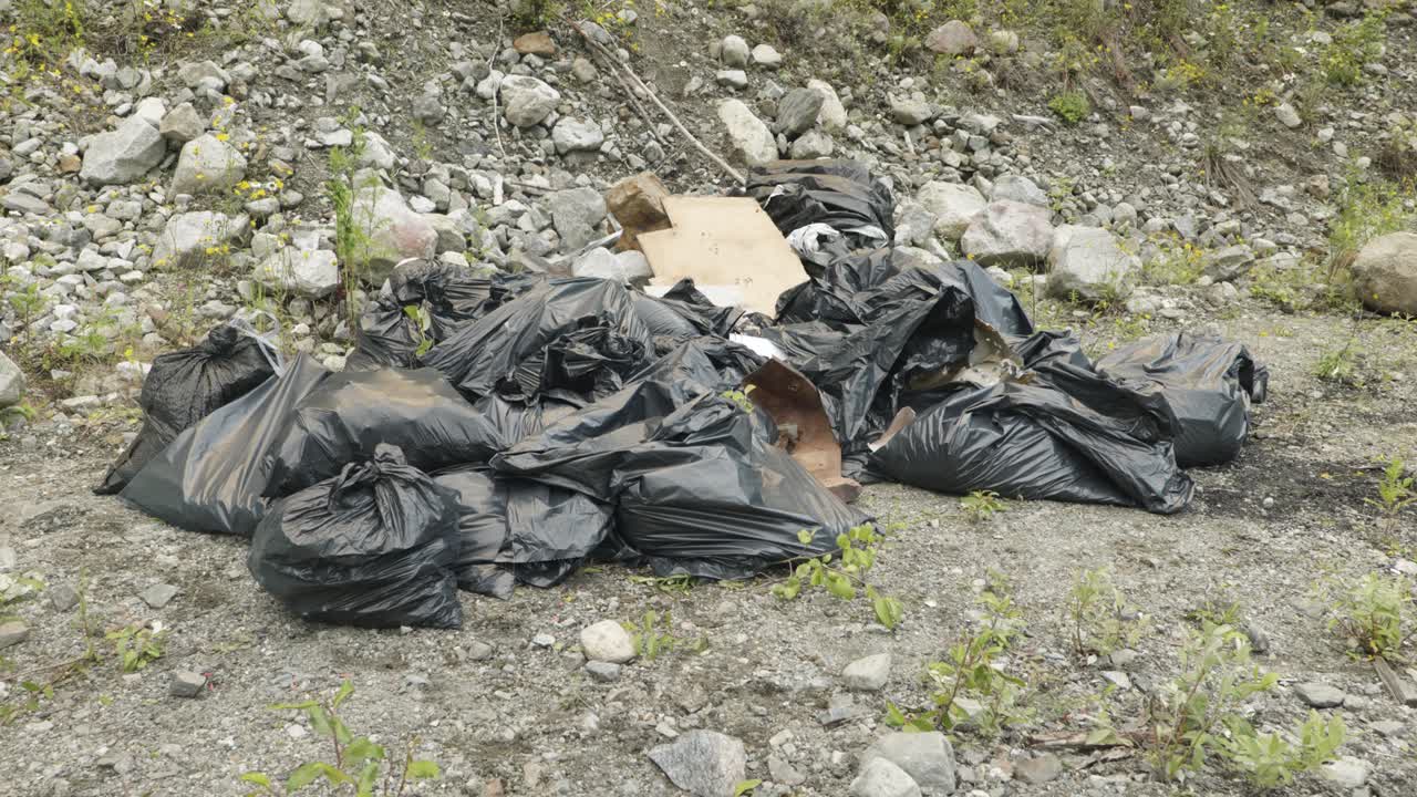 4K cinematic dolly into a pile of garbage bags in the outdoors