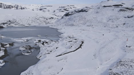 Luftaufnahme-Einer-Gruppe-Von-Fallschirmspringern,-Die-In-Einem-Verschneiten-Isländischen-Tal-Gelandet-Sind