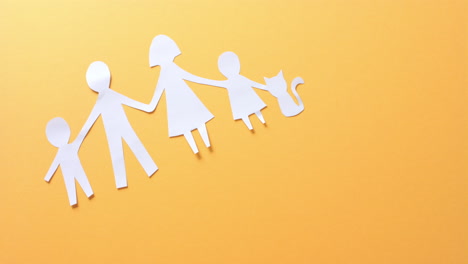 close up of family with cat made of white paper on yellow background with copy space