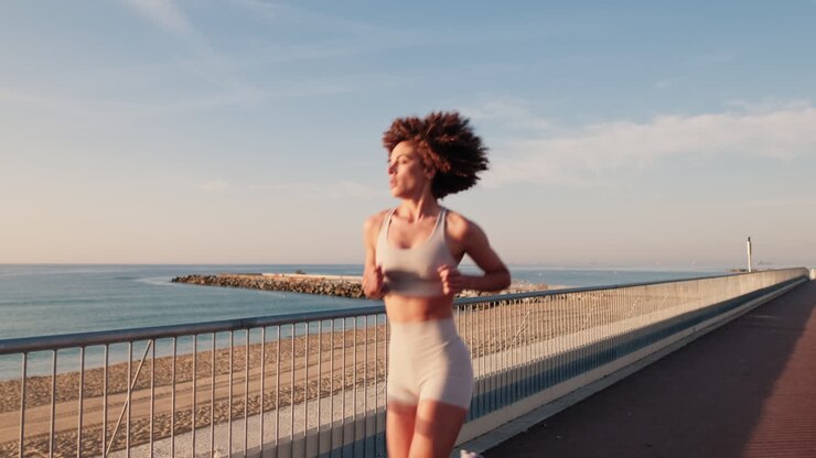 Woman Running By The Sea At Sunrise