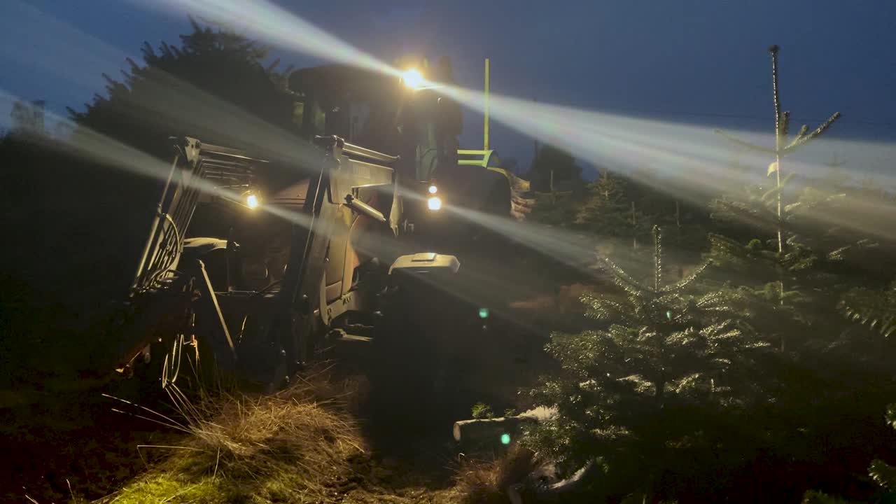 gran tractor agrícola moviéndose en el camino por la noche