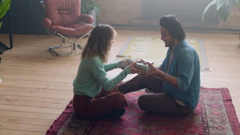 Happy-young-couple-sitting-on-the-carpet