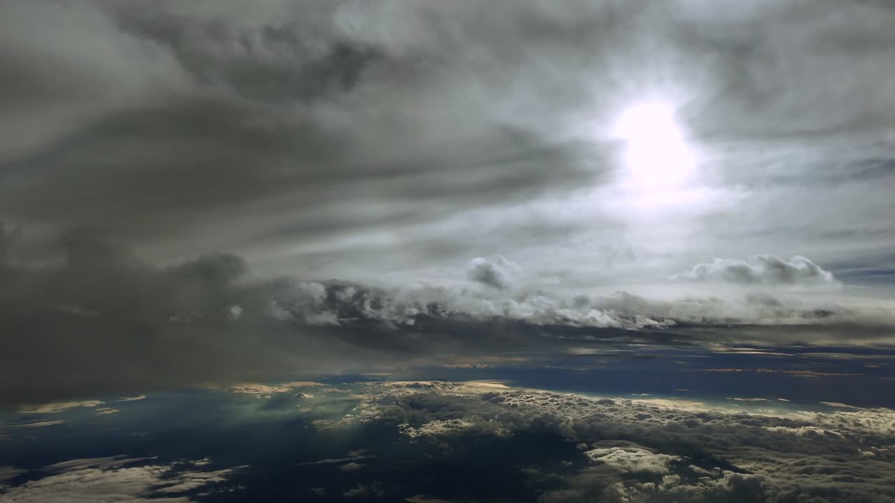 Pilot’s eye aerial view in a high-altitude flight in the upper atmosphere, while flying through layers of ethereal clouds with sunlight and shadows, and a faded sun shining above. Ultra-realistic 4K