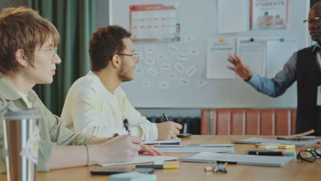 cheerful teacher talking to multi-ethnic immigrant students during class