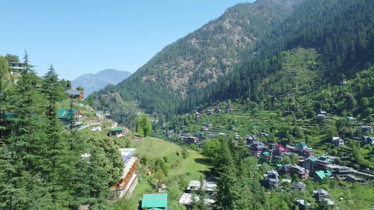 Aerial view short of Jibhi Himachal Pradesh in India. Houses and trees in the mountainous area. Faguli festival is one of the biggest festival in Jibhi. The traditional houses here have stone roofs.