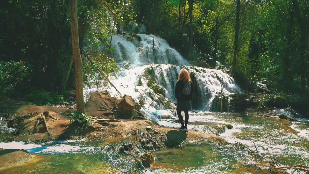 hermosa cinemagrafía 4k uhd de cascadas en el parque nacional krka en croacia a principios de verano con una mujer joven