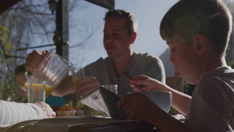 family eating breakfast together outdoors