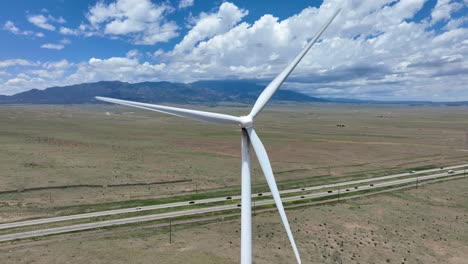 wind turbine in rural usa with mountain range in background