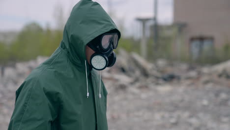 man in chemical protection suit. human in safety uniform and gas mask standing in abandoned place. biological attack.