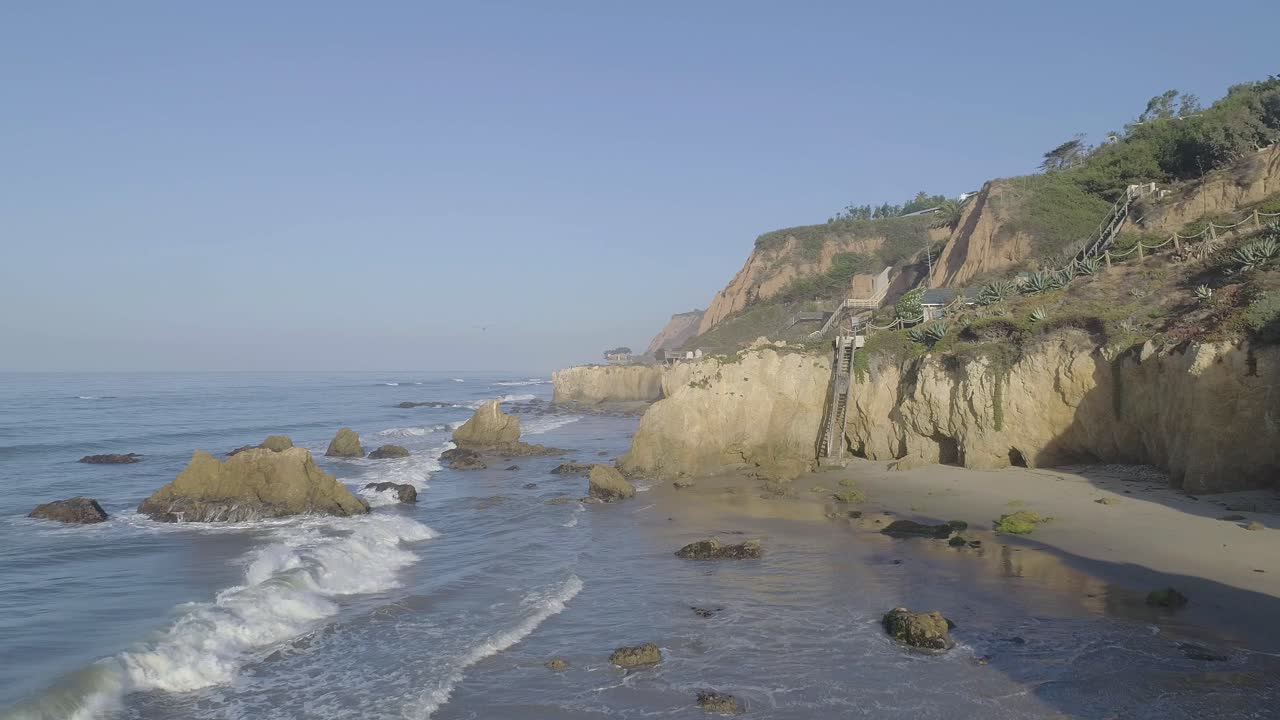 캘리포니아 말리부에서 흐릿한 여름 아침 파도와 바위를 깨는 엘 투우사 해변의 공중 촬영