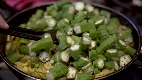 fresh sliced okra being added into saucepan and