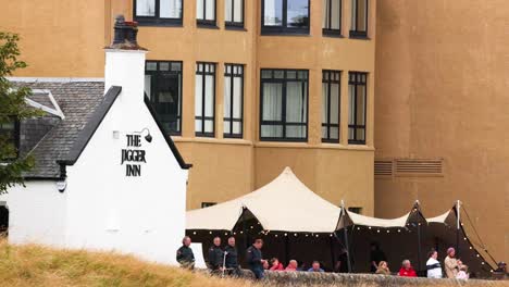 people socializing outside a historic inn