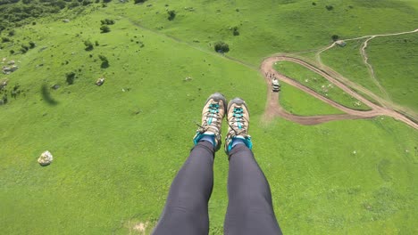 First-Person-Perspective-Paragliding.-Paragliding-pilot-fly-paragliders-among-clouds-and-green-mountains.