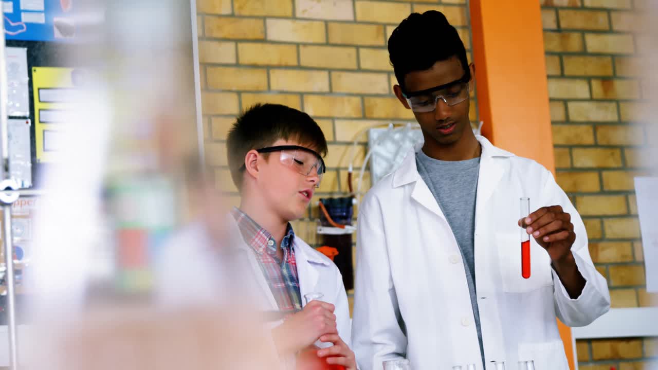 niños de escuela atentos haciendo un experimento químico en el laboratorio