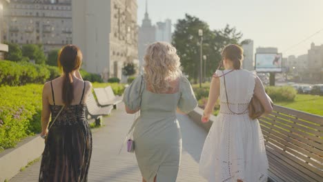 three women walking in a city park